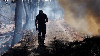 Adobe Stock/Arafat Um bombeiro observa os restos fumegantes de um incêndio florestal no sul da França